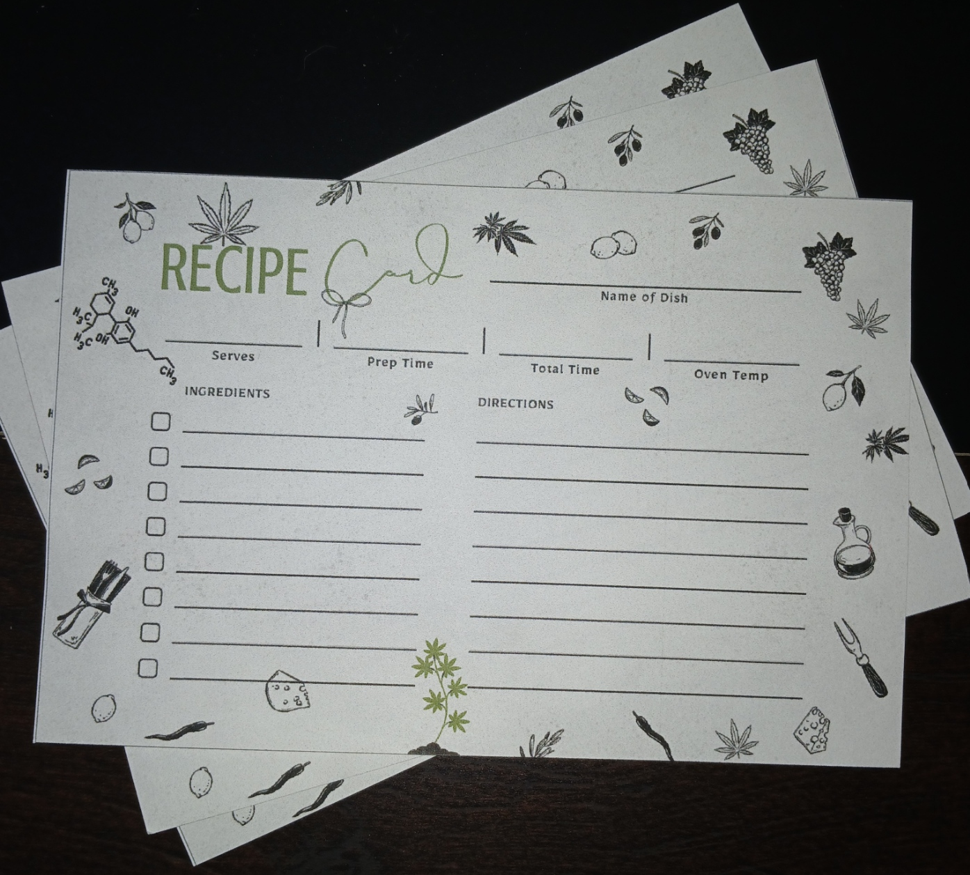Stack of recipe cards with illustrations on a dark surface