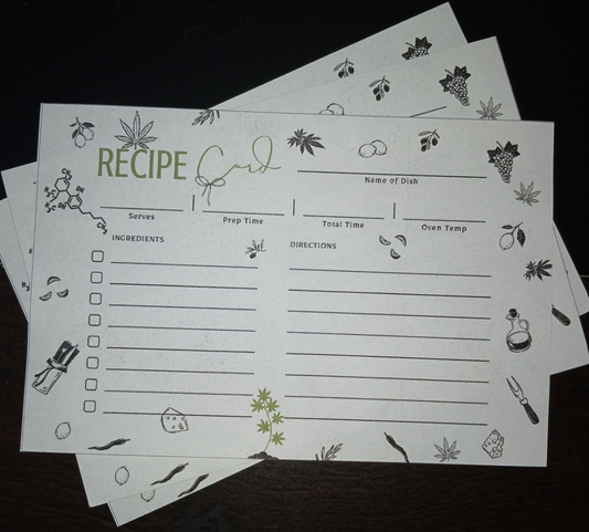 Stack of recipe cards with illustrations on a dark surface